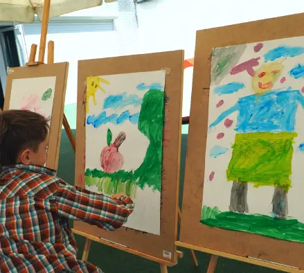 Child painting outdoors symbolizing creativity in Sustainable Supply Chain Consulting