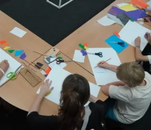 Children crafting with paper symbolizing Benefits of Sustainable Consulting in communities