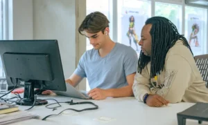 Two colleagues collaborating on laptop project in office for Social Impact Consulting