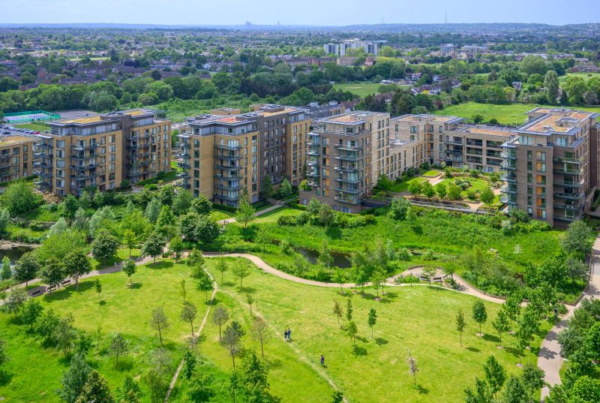 Aerial view of eco-friendly residential buildings surrounded by green spaces, illustrating climate and carbon reduction strategies