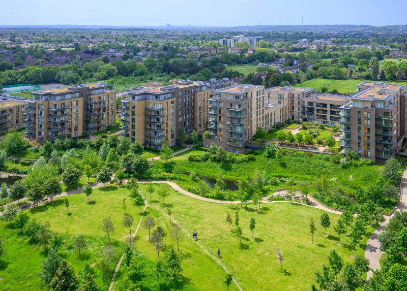 Aerial view of eco-friendly residential buildings surrounded by green spaces, illustrating climate and carbon reduction strategies